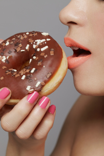Young adult woman eating doughnut