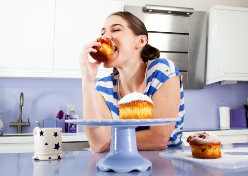 Young woman eating muffin